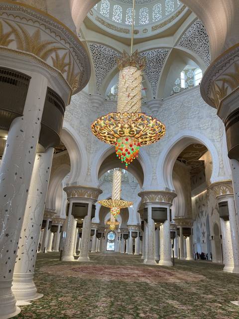 Grand Mosque interior with chandeliers and columns.