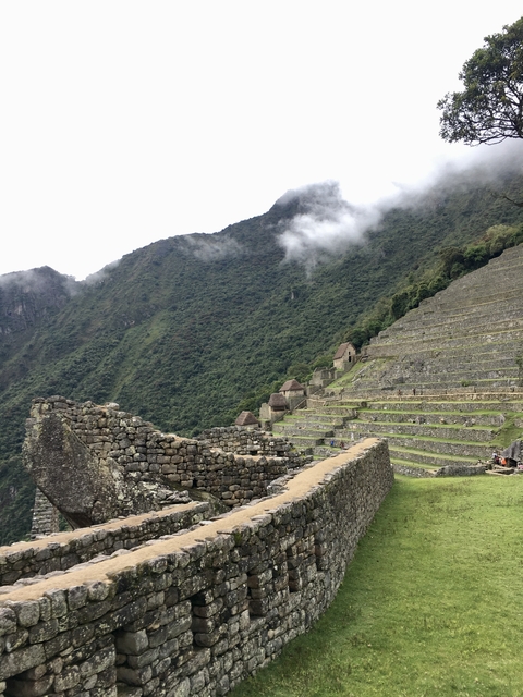 Terraces and ruins of Machu Picchu with tourists exploring.