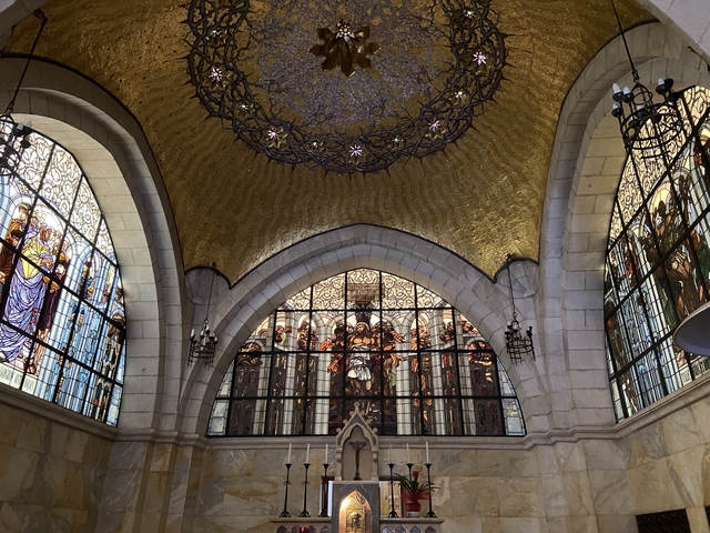 Interior of a building with stained glass and arched ceilings.
