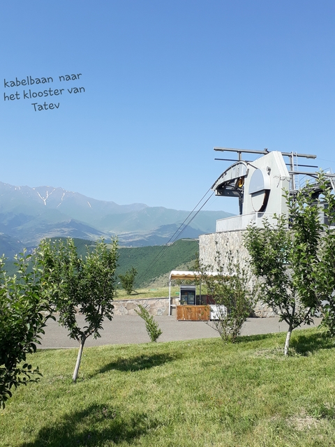 Cable car station with mountainous backdrop.