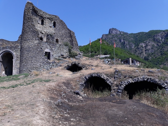 Stone ruins integrated with natural landscape.