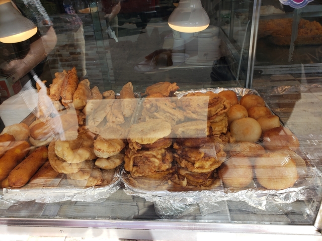 A display of various fried foods behind a shop window.