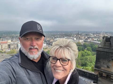 Couple taking a selfie with a cityscape view.