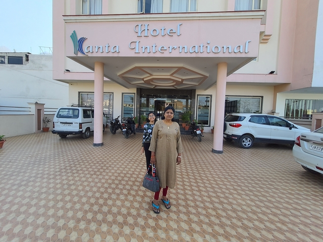 Two people standing outside a hotel building.