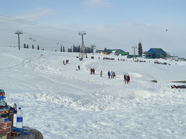Ski resort with ski lifts and people on snowy slopes.