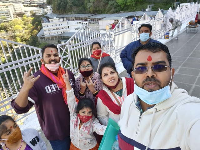 Group selfie with people wearing masks outside.