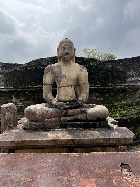 Ancient stone Buddha statue sitting in meditation.