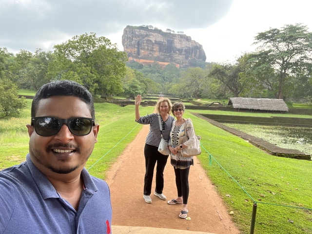 People posing on a path with Sigiriya rock in the background.