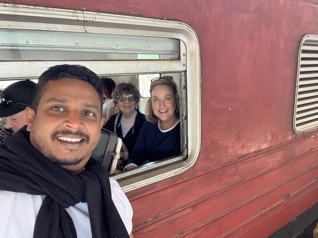 People sitting inside a train looking at the camera.