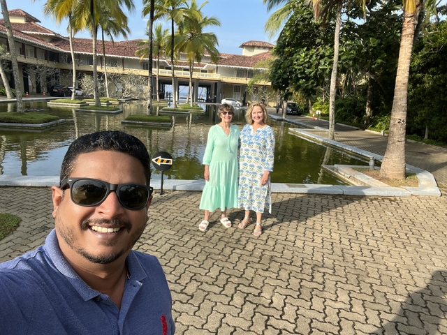 Two people posing in front of a hotel entrance.