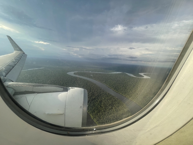 Aerial view from a plane window showing a winding river.