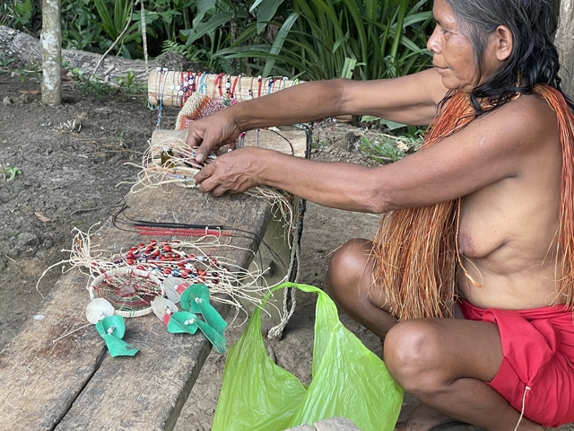 Person crafting jewelry out of natural materials.