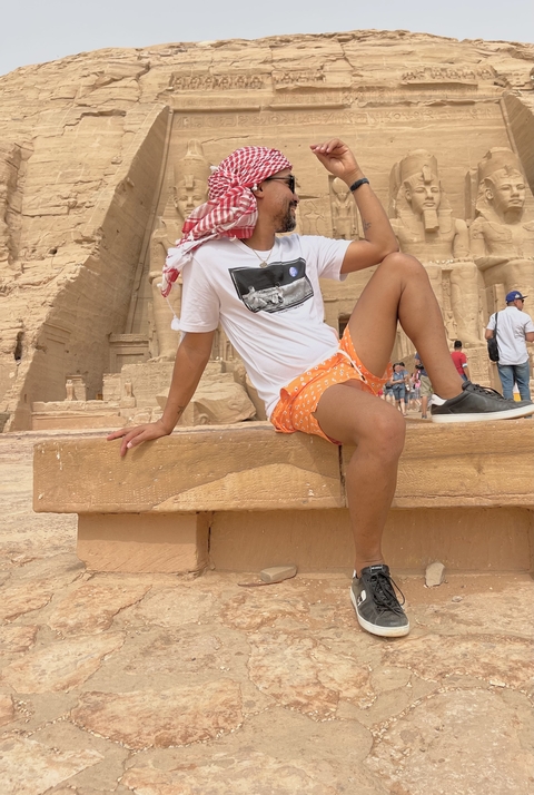 Person seated at the entrance of an ancient temple.