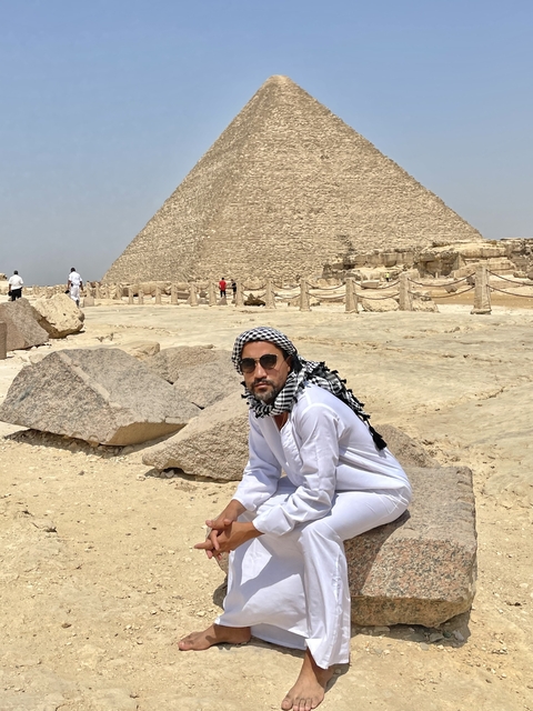 Person resting by the Giza pyramids.