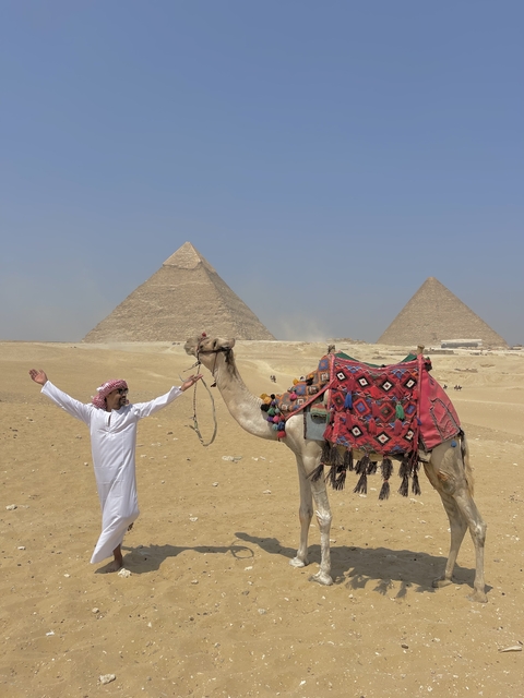 Person with a camel near the pyramids.