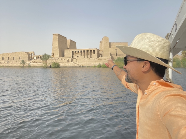 Person pointing to a temple by the river.