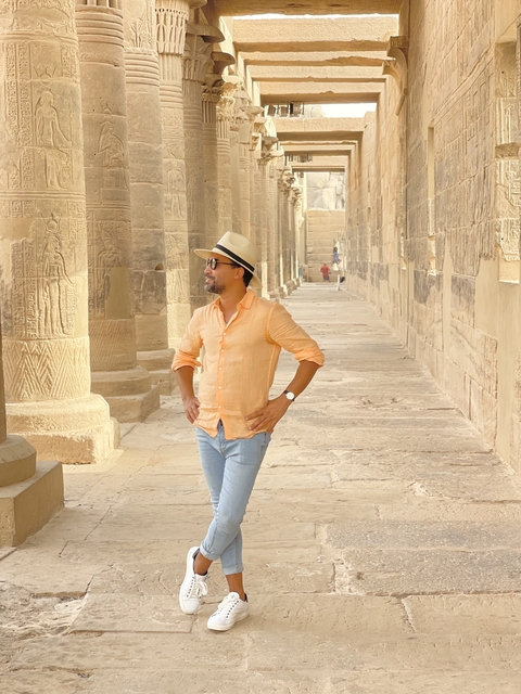 Person walking through ancient stone columns.