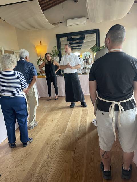 Group of people standing on a wooden floor in a room.