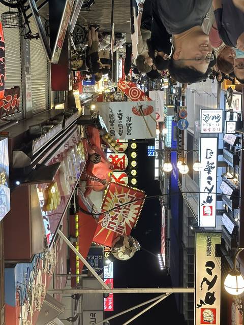 Busy street at night with various signs and lights.
