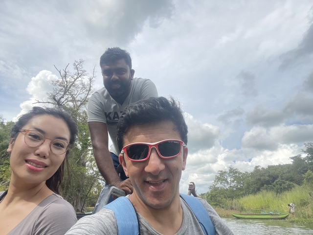 Selfie of travellers in an open vehicle under a partly cloudy sky during safari