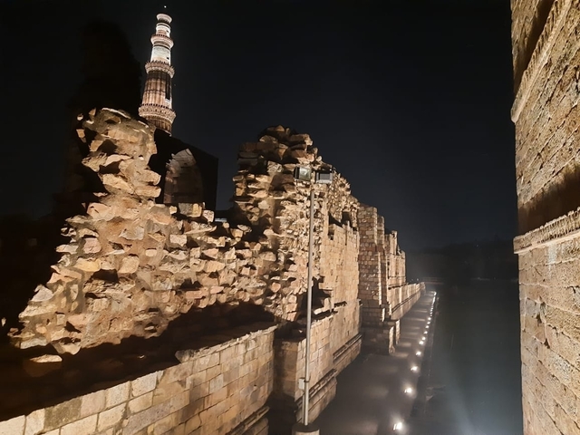 Ancient stone structure in New Delhi lit by artificial light at night.