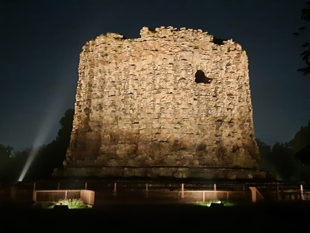 Ruins of the Alai Minar in New Delhi, lit up at night.