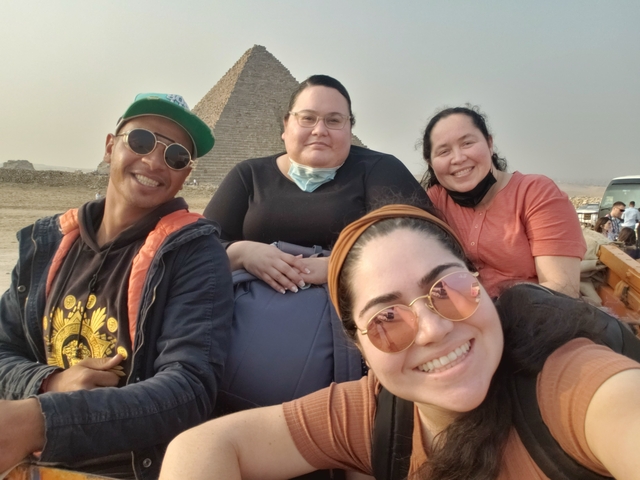 Group selfie with pyramids in the background in Egypt.