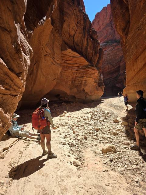 Person exploring a rock canyon with a backpack