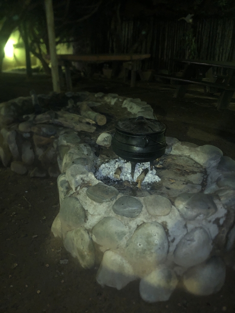 Cooking pot over an open fire at night.