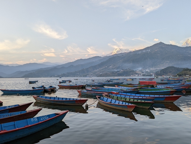 Boats on a lake with mountains in the background.