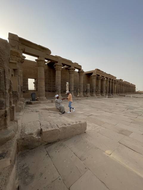 Person exploring ancient ruins with columns.