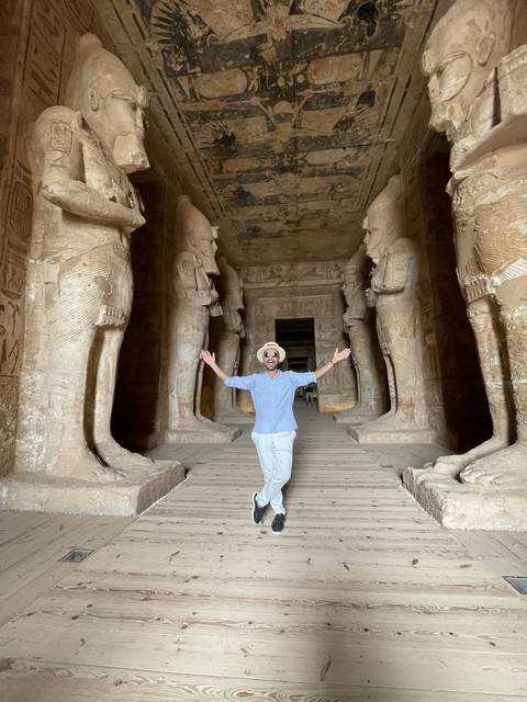 Person inside an ancient temple with hieroglyphs.