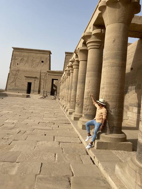 Person posing horizontally on stone columns.