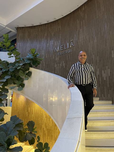Person in a hotel interior near a staircase.