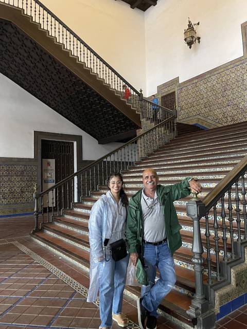 Two people on stairs inside a grand building.