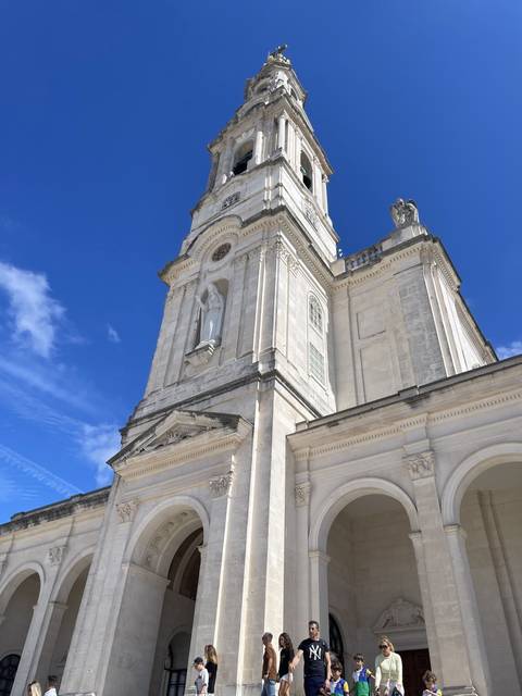 Large cathedral with people around.