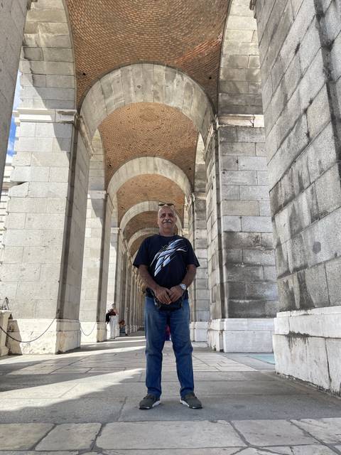 Person standing under a stone archway.