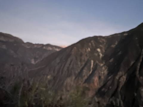 Blurry image of mountains under a cloudy sky.