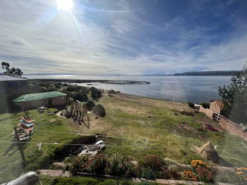 View of a lake and mountains from a grassy area.