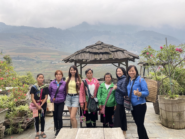 Group of people with vibrant clothing posing in front of mountains.