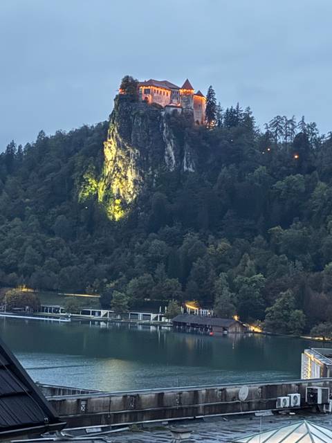 Castle-like structure atop a hill at dusk.