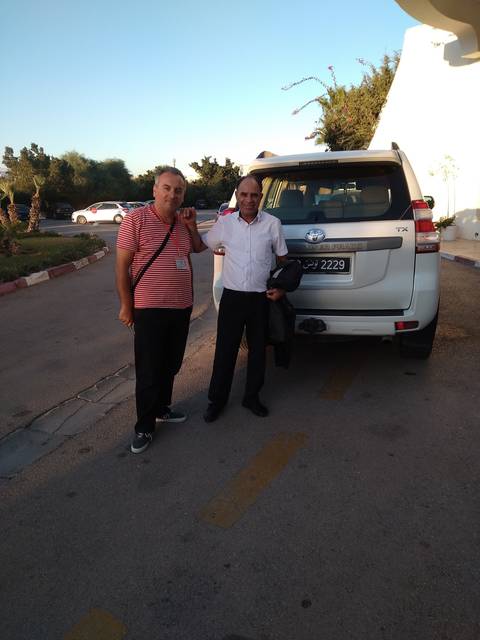 Two men posing in front of a van.