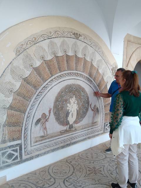 Man pointing at an ancient mosaic.