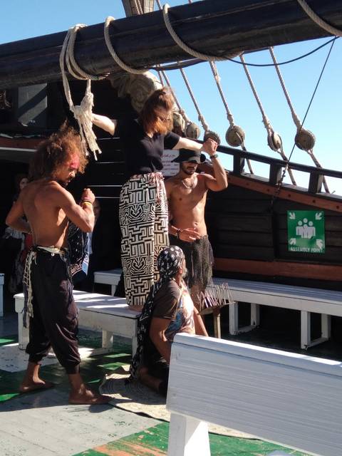 People dressed as pirates on a ship deck.