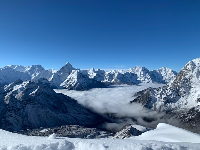 Himalayan range above a valley filled with soft cloud blanket under bright morning light