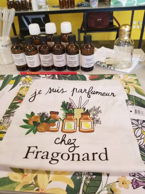 Perfume bottles and a decorative textile with French writing.