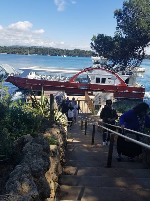 Dock area with a red boat and people walking down stairs.