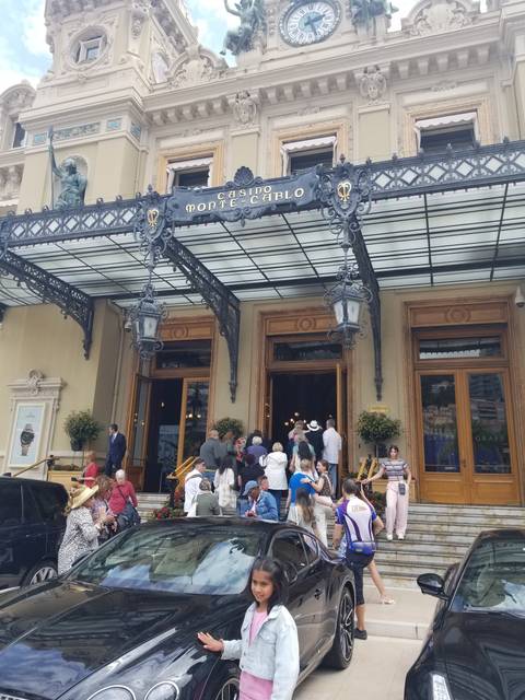 Elegant building entrance with a clock and people milling around.