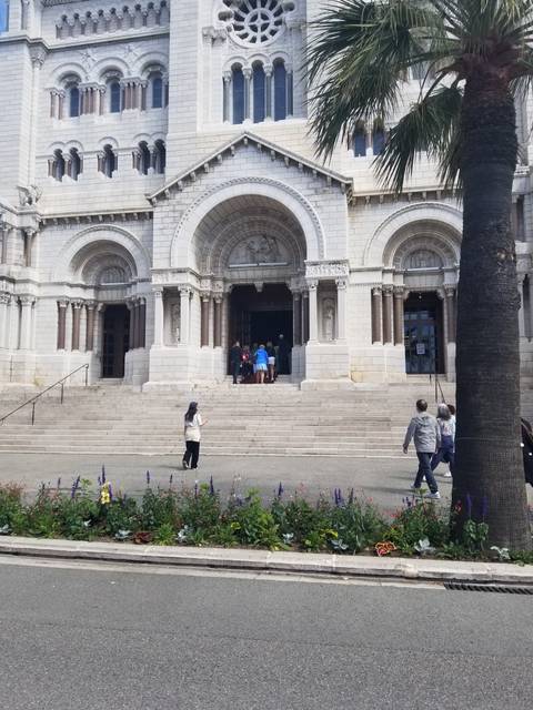 A grand entrance to a church building with people outside.