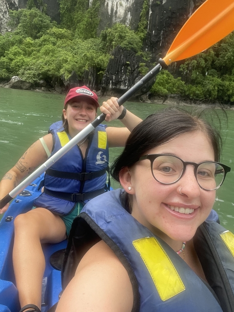 Couple kayaking on a green river.